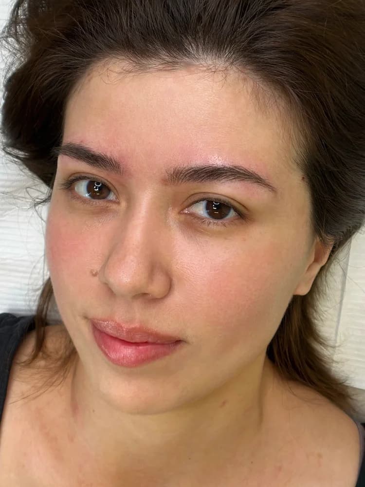 Close up of woman's face showing eyebrow cosmetic ink work